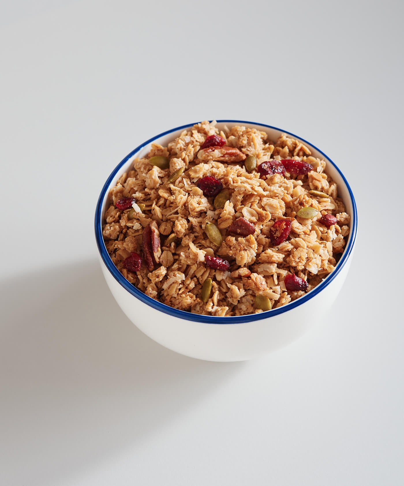 Bowl of granola with dried fruits on a white background